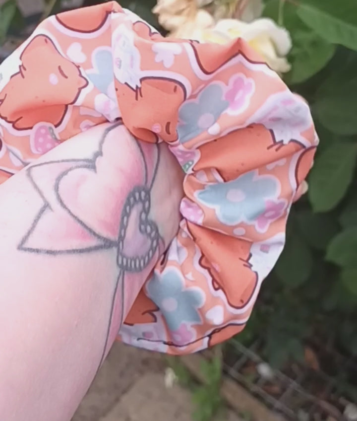 Capybara-patterned scrunchie on a glitter background